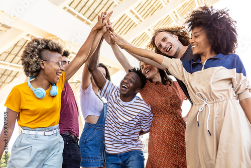 Group of multiracial teenager friends stacking hands outdoors - Community and teamwork concept with happy diverse united young people with hands in stack