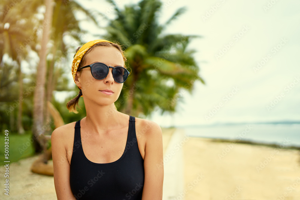 Vacation on the seashore.Young woman in sunglasses on the tropical beach with palm trees. Vacation on the seashore.Young woman in sunglasses on the tropical beach with palm trees.