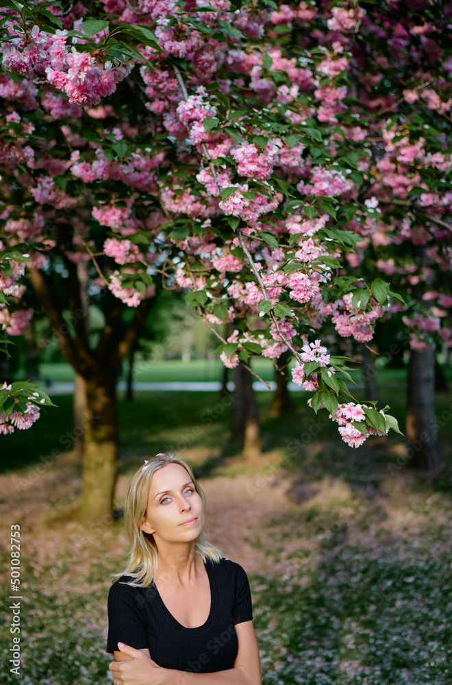 Blonde young woman at blossom garden. Blonde young woman at blossom garden.