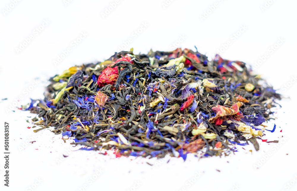 a scattering of dry green tea with the addition of cornflower flower, pomegranate flower, blue tea. A mixture of different types of tea on a white background a scattering of dry green tea with the addition of cornflower flower, pomegranate flower, blue tea. A mixture of different types of tea on a white background