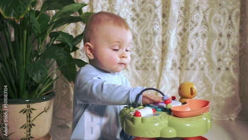 happy little girl sitting and banging on toy drum