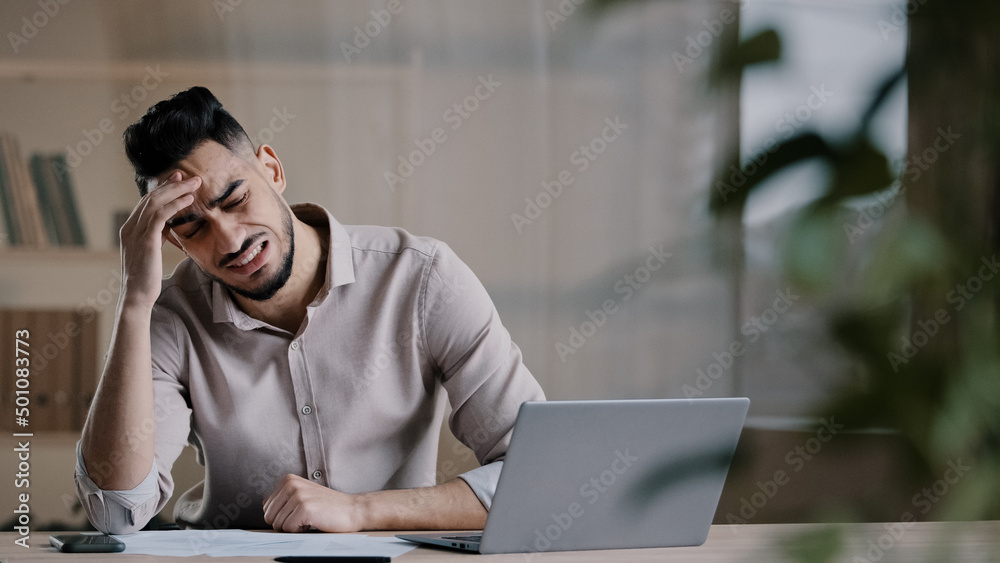 Unhappy shocked arabian male worker look at laptop screen feeling nervous upset with bad news problems study failure exam frustrated young man confused unexpected error on computer losing online bets Unhappy shocked arabian male worker look at laptop screen feeling nervous upset with bad news problems study failure exam frustrated young man confused unexpected error on computer losing online bets