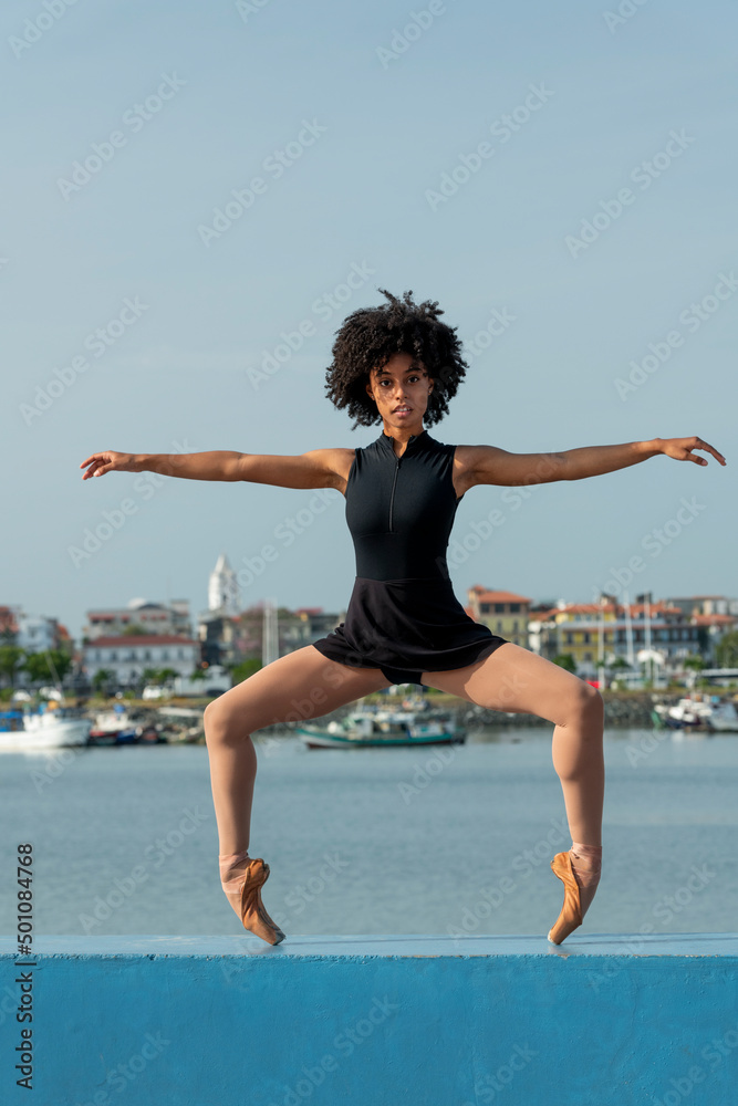 Fototapeta premium Young latin female ballet dancer dancing in the streets, along the bay of Panama - stock photo