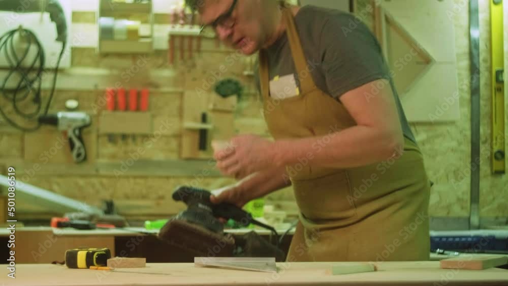 A mature carpenter makes works in his carpentry workshop, measures the wood by molting A mature carpenter makes works in his carpentry workshop, measures the wood by molting