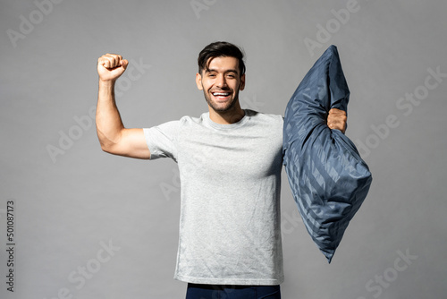 Cheerful Caucasian man with pillow showing bicep Fototapet
