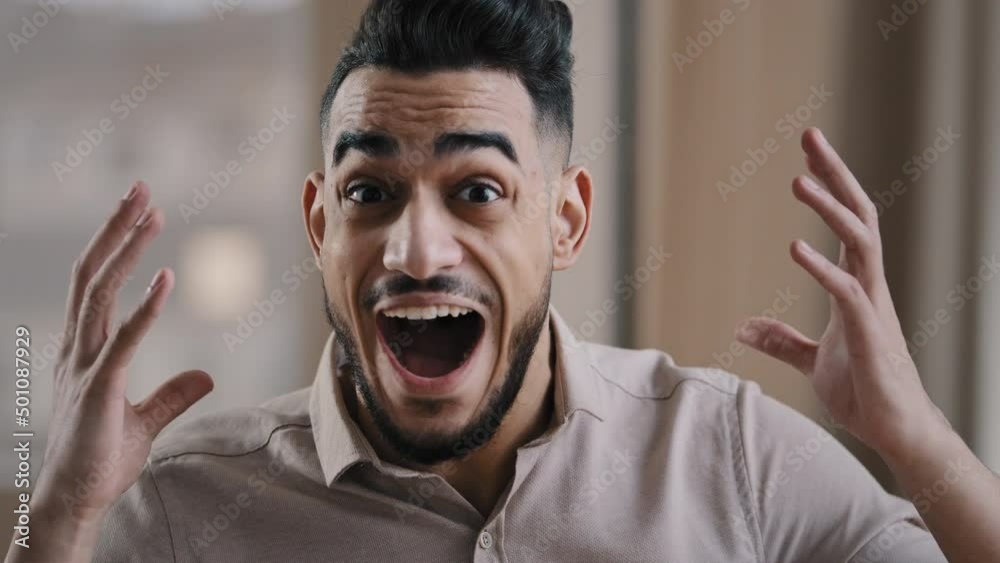 Close up shocked happy young hispanic male business man professional worker surprised looking at camera make big eyes rejoice victory amazed guy winner demonstrate wow reaction joyful face expression
