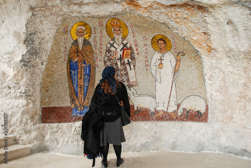 Pilgrim in front of an icon in Ostrog Monastery in Montenegro. Women are praying in Manastir Ostrog.   photo