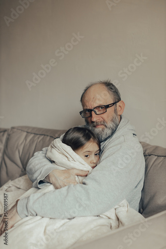 Ukrainian excited gray-haired man protects his little frightened granddaughter. Stop the war. Pray for Ukraine. We support Ukraine.