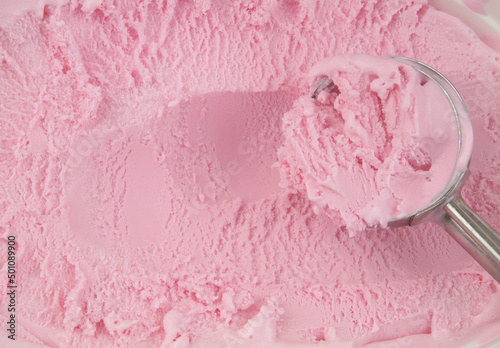 Strawberry ice cream and ice-cream scoop close up