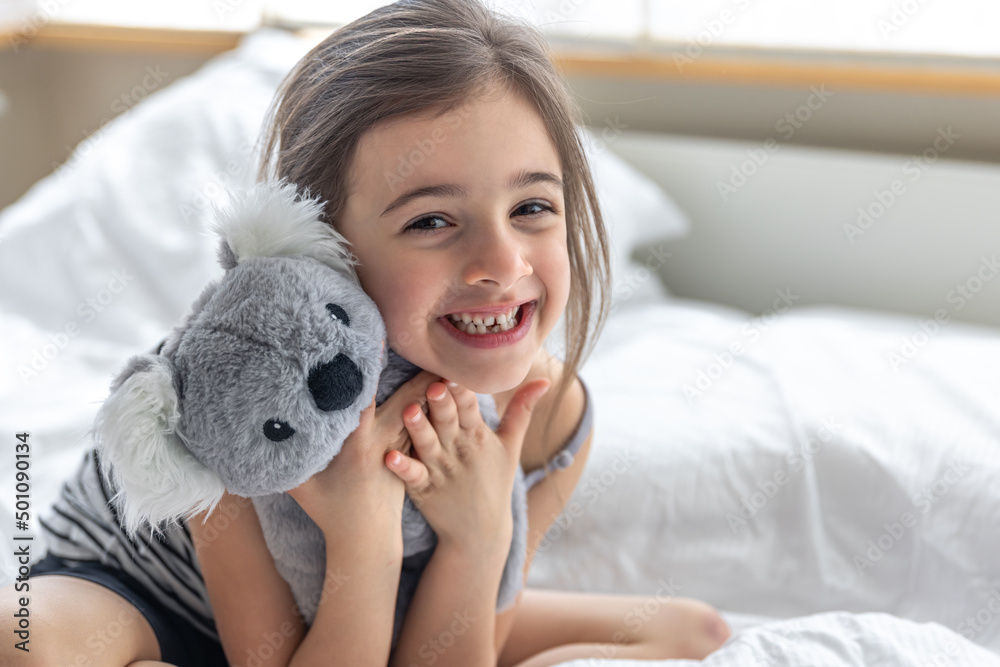 Happy little girl with soft toy koala in bed. Happy little girl with soft toy koala in bed.