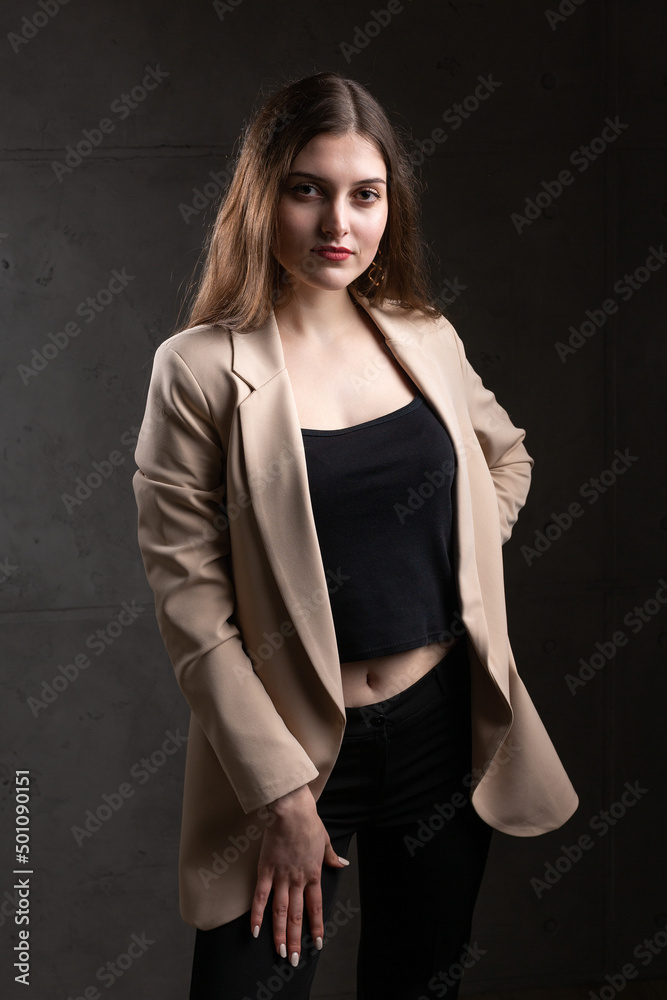 Portrait of a young brunette with long hair in the studio. Dramatic photo in dark colors. Portrait of a young brunette with long hair in the studio. Dramatic photo in dark colors.