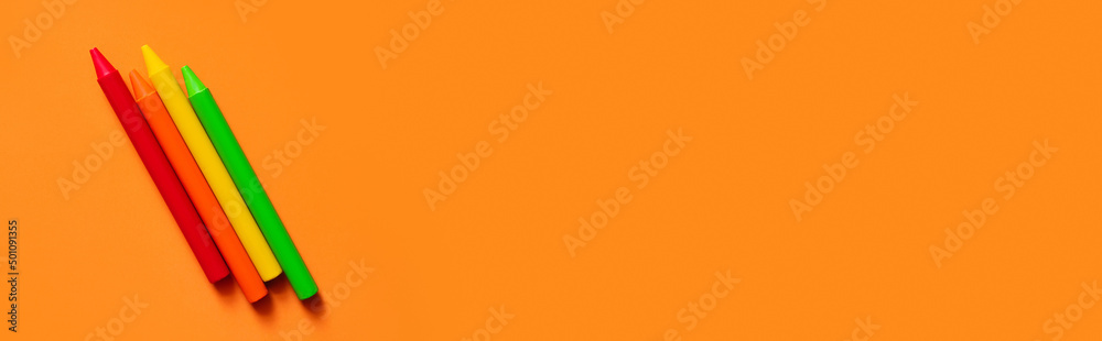 top view of colorful crayons on orange background, banner. - obrazy, fototapety, plakaty 