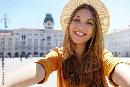 Tourism in Europe. Self portrait of smiling young tourist woman visiting Trieste, Italy. photo