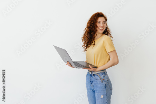 Portrait of happy young woman holding laptop on a white background