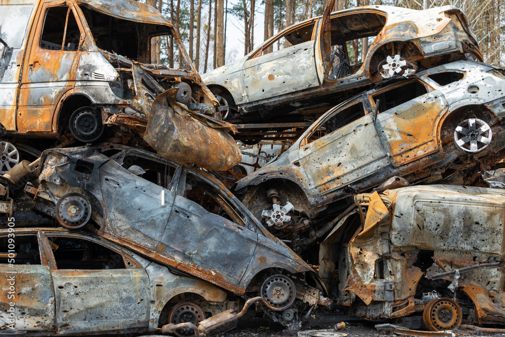 Many shot and destroyed cars of civilians at the car graveyard in Irpin, Ukraine. War in Ukraine. Car accident. Many shot and destroyed cars of civilians at the car graveyard in Irpin, Ukraine. War in Ukraine. Car accident.