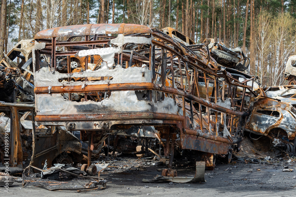 Many shot and destroyed cars of civilians at the car graveyard in Irpin, Ukraine. War in Ukraine. Car accident.