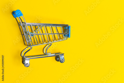Empty Trolley Design Shopping or Sale Cart Placed Over Seamless Solid Yellow Background With Space for Text