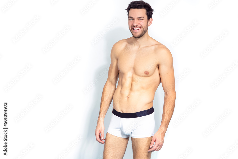 Smiling Positive Sensual Caucasian Handsome Brunet Man Posing in Underware Against White Background. Smiling Positive Sensual Caucasian Handsome Brunet Man Posing in Underware Against White Background.
