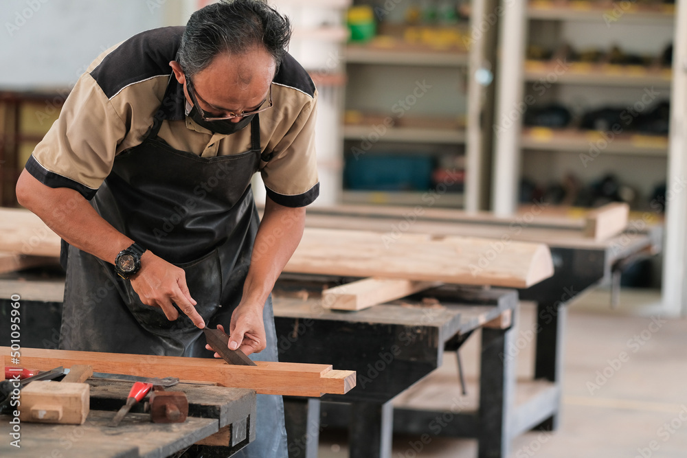 Carpenter working on wood craft at workshop to produce construction material or wooden furniture Carpenter working on wood craft at workshop to produce construction material or wooden furniture