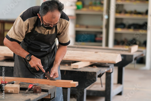 Carpenter working on wood craft at workshop to produce construction material or wooden furniture