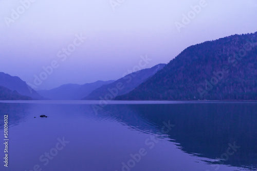 Lake Teletskoye, Altai Republic, Siberia, Russia. Blue clear sky and Mirror of lake. Abstract panoramic landscape, nature environment scene, monochrome background with tonal perspective