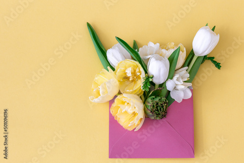 Flowers in an envelope on a colored background  flat lay.