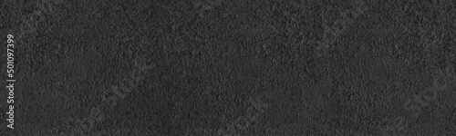 Black painted roughcast wall wide panoramic texture. Dark gray pebble dash coarse plaster. Abstract large long background photo