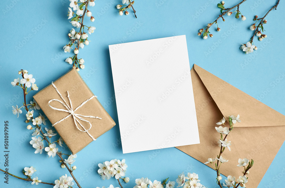 Greeting card mockup with gift and white flowers on blue Greeting card mockup with gift and white flowers on blue