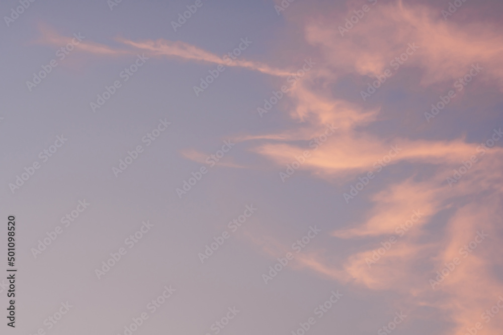 Background image of blue bright sky with pastel pink and white clouds. Beautiful sky pattern on clear sunny day