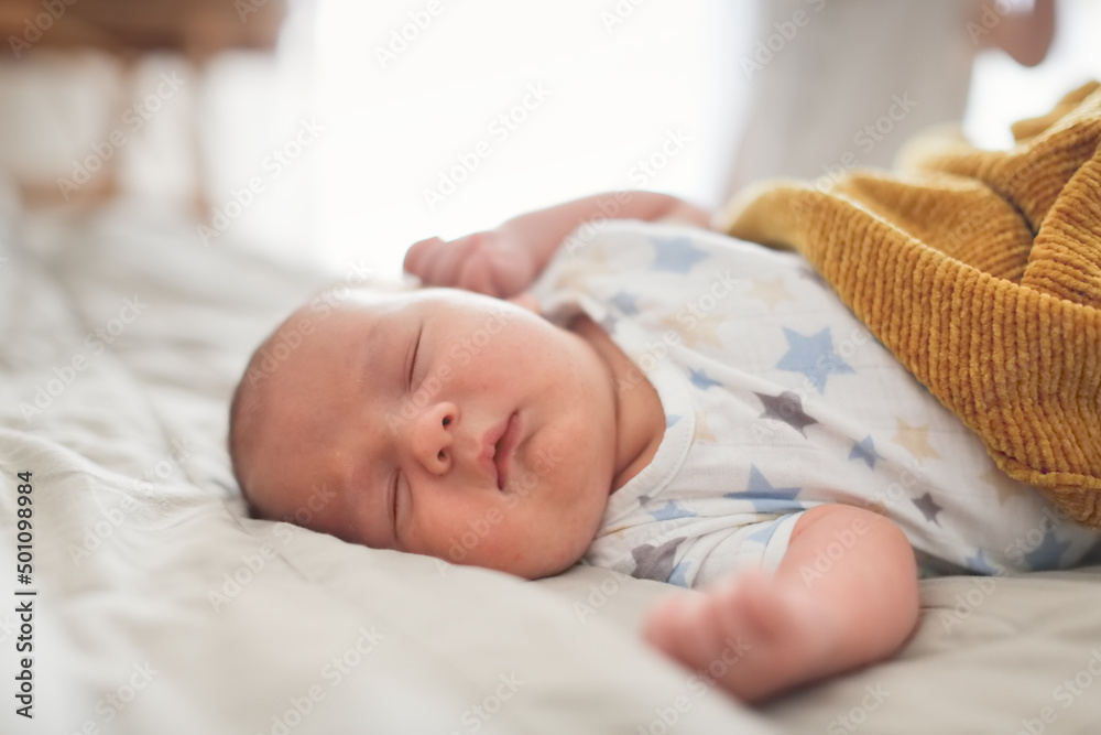 Cute sleeping chubby baby in a bed on a linen bedspread, a baby with chubby cheeks sleeps on a big bed Cute sleeping chubby baby in a bed on a linen bedspread, a baby with chubby cheeks sleeps on a big bed
