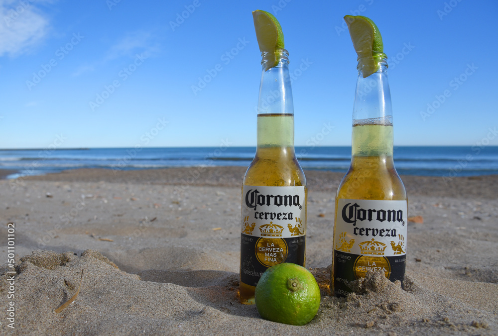 Corona Cerveza Beer Bottles on the beach near the sea. cold beer with lime in the sand. Corona