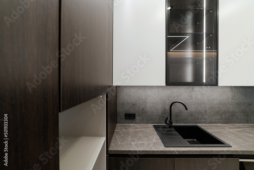 new clean kitchen with black sink metal faucet and facades