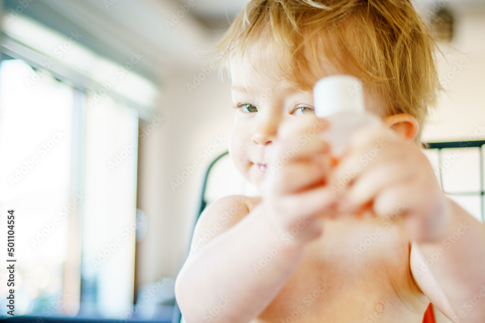 Child at the table in a high chair. Funny kid is naughty. The baby plays instead of breakfast. The merry infant refuses to eat