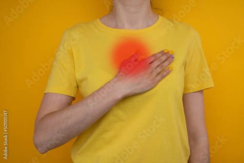 Woman's hand on chest with red spot as suffering on chest pain. Female suffer from heart attack,Lung Problems,Myocarditis, heart burn,Pneumonia or lung abscess, pulmonary embolism day