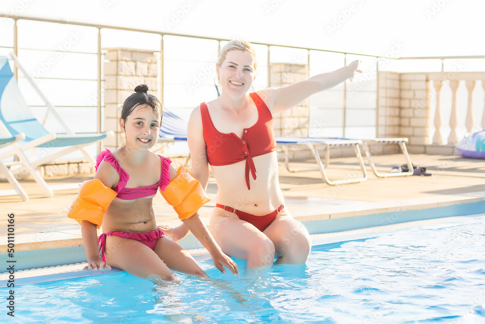 A mother and daughter playing in the pool