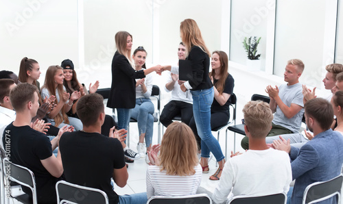 young people shaking hands in a circle of like-minded people