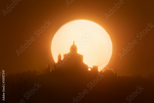 Sun behind the silhouette of San Luca Sanctuary during sunset, Bologna, Emilia Romagna photo