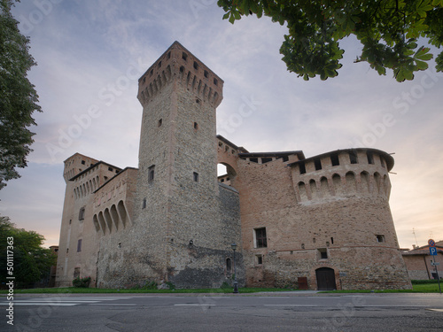 Medieval castle of Vignola with fortified tower, framed by tree branches, Vignola, Emilia Romagna