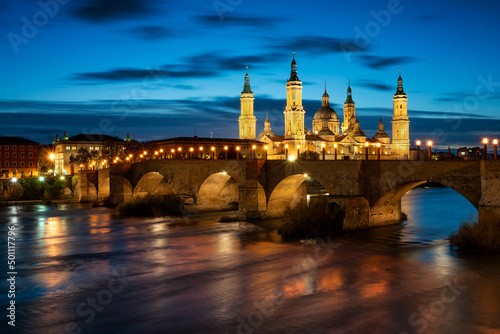 Basilica del Pilar Cathedral with stone bridge crossing Ebro River at night, Zaragoza, Aragon