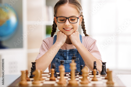Happy girl playing chess at school Fototapet