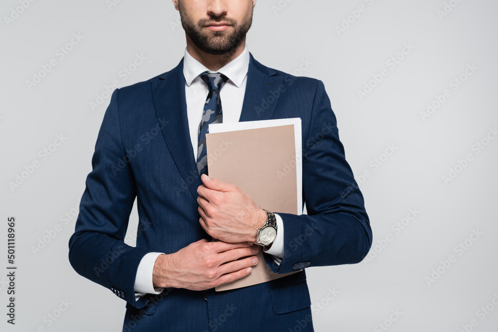 partial view of economist in blue blazer holding folder isolated on grey. partial view of economist in blue blazer holding folder isolated on grey.