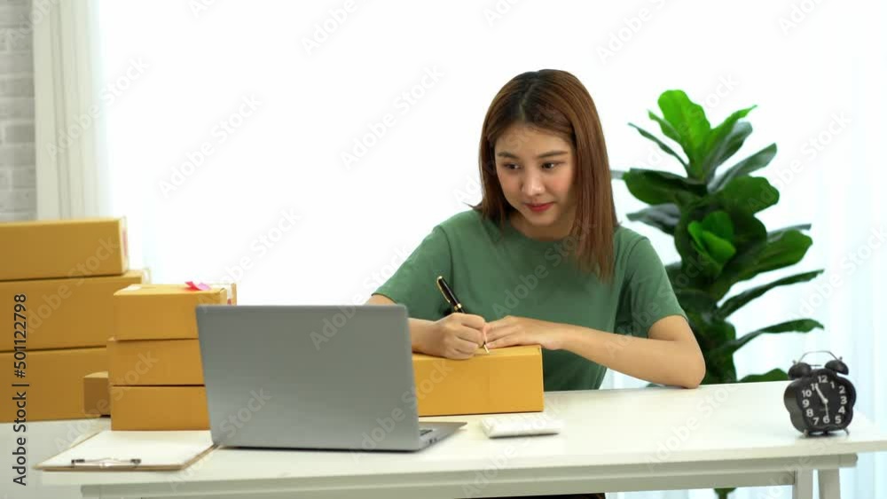 Young Asian businesses start with an online business or an idea. SME young women working with boxes at home and laptops to take name orders and deliver. Young Asian businesses start with an online business or an idea. SME young women working with boxes at home and laptops to take name orders and deliver.
