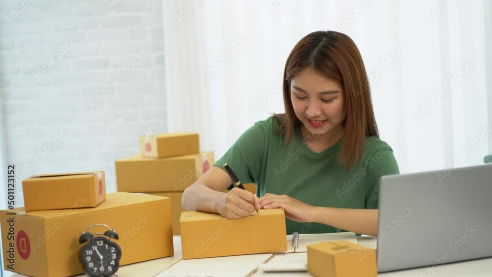 Young Asian businesses start with an online business or an idea. SME young women working with boxes at home and laptops to take name orders and deliver. Young Asian businesses start with an online business or an idea. SME young women working with boxes at home and laptops to take name orders and deliver.