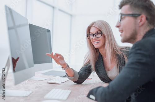 business colleagues discussing work tasks sitting at a computer table