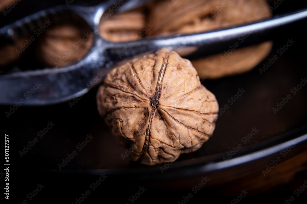 Fototapeta premium Nuts in a black plate