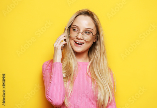 lady using mobile phone over yellow background.