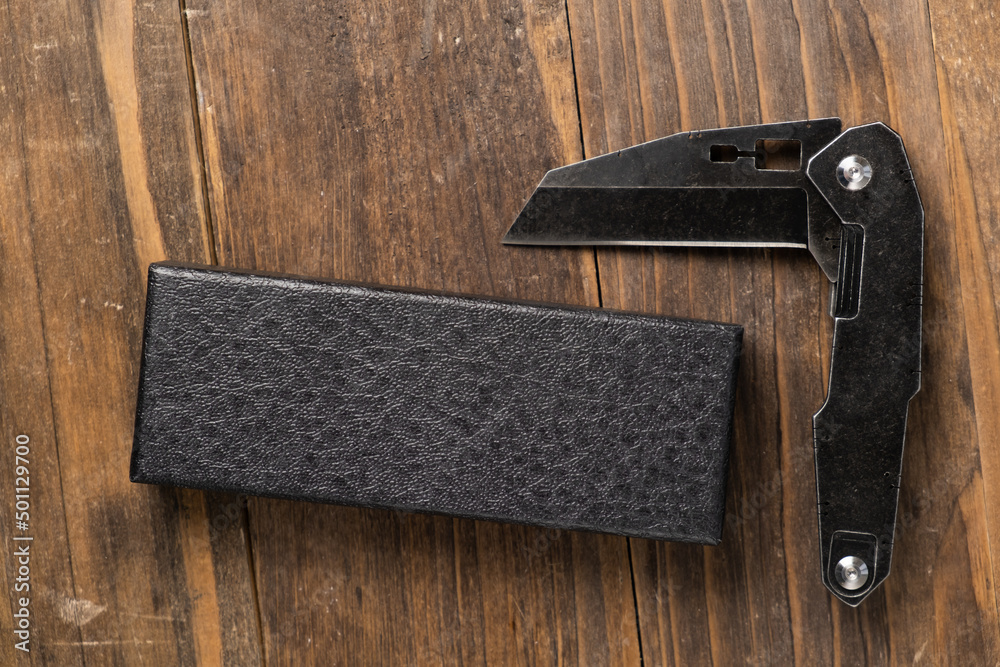 stainless steel folding knife with wooden handle and other everyday carry (EDC) items for men. closeup at folding knife. stainless steel folding knife with wooden handle and other everyday carry (EDC) items for men. closeup at folding knife.
