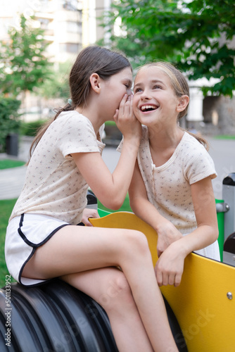 sisterhood, friendship. two charming teen girls having fun on a modern playground. sister, bffs communication