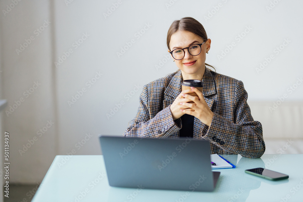 Young business woman sitting at table and taking notes in notebook drink coffee Young business woman sitting at table and taking notes in notebook drink coffee