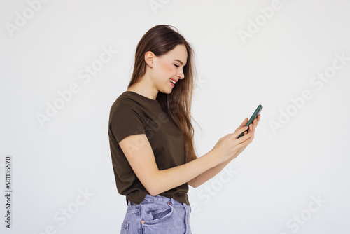 Portrait of a smiling woman holding smartphone over white background